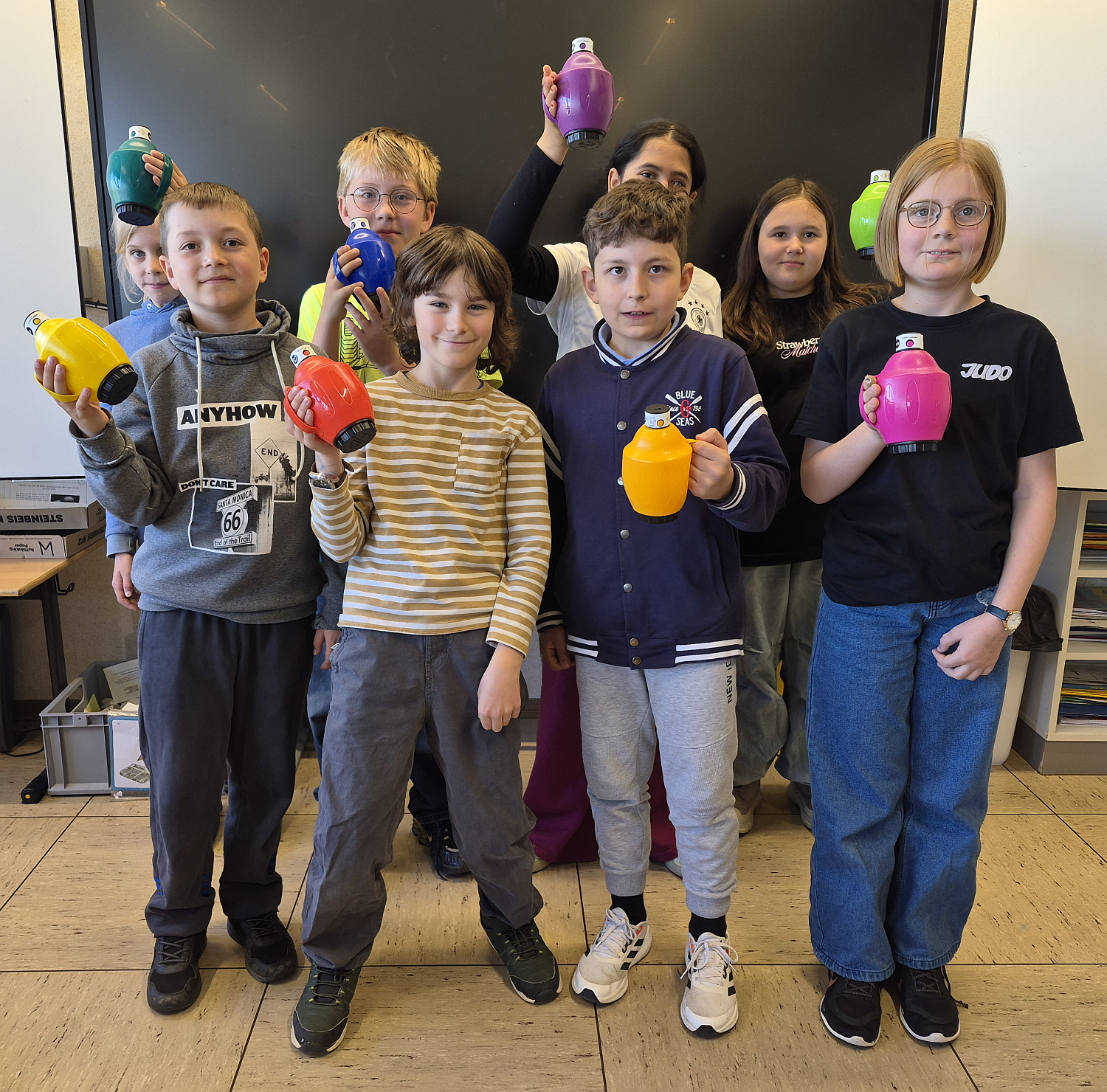 Kinder stehen vor einer Tafel und haben Sound Bellows in der Hand
